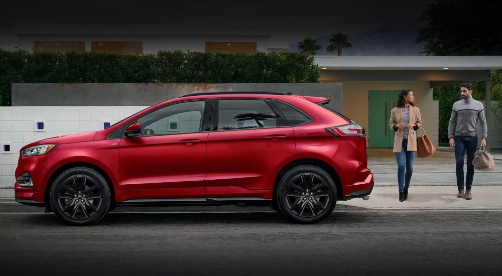 A red 2023 Ford Edge is shown parked near a house.