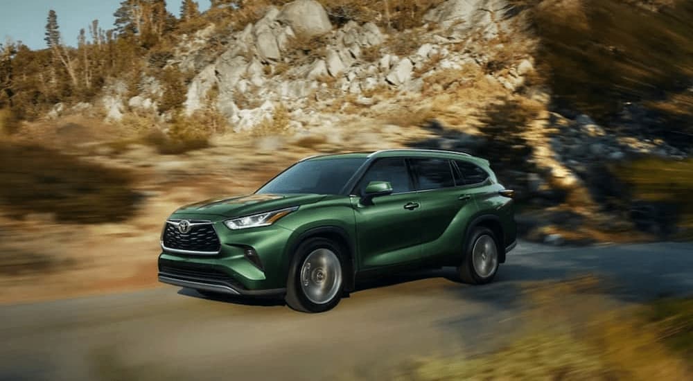 A green 2023 Toyota Highlander is shown driving off-road.