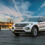 A white 2023 Ford Explorer is shown parked near a carnival after winning a 2023 Ford Explorer vs. 2023 Toyota Highlander comparison.