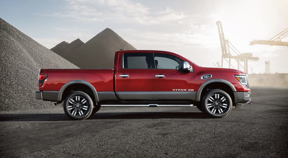 A red 2023 Nissan Titan XD is shown parked off-road after losing a 2023 Ford F-150 vs 2023 Nissan Titan comparison.