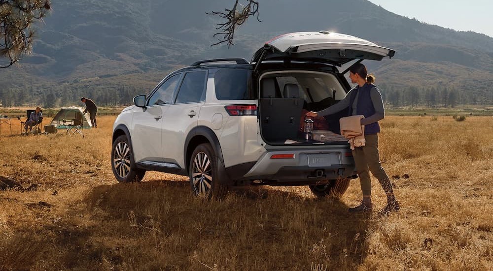 A white 2023 Nissan Pathfinder is shown parked near a mountain.