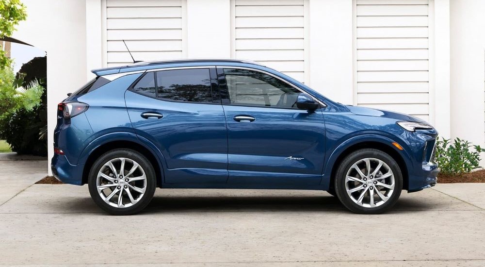 A blue 2024 Buick Encore GX Avenir is shown from the side parked on a driveway.