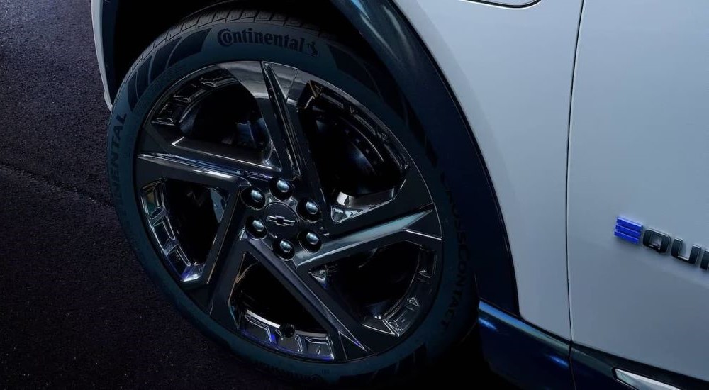 A close up shows the black wheel on a white 2024 Chevy Equinox EV.