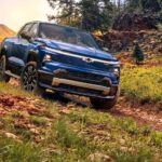 A blue 2024 Chevy Silverado EV RST is shown from the front at an angle while off-road.