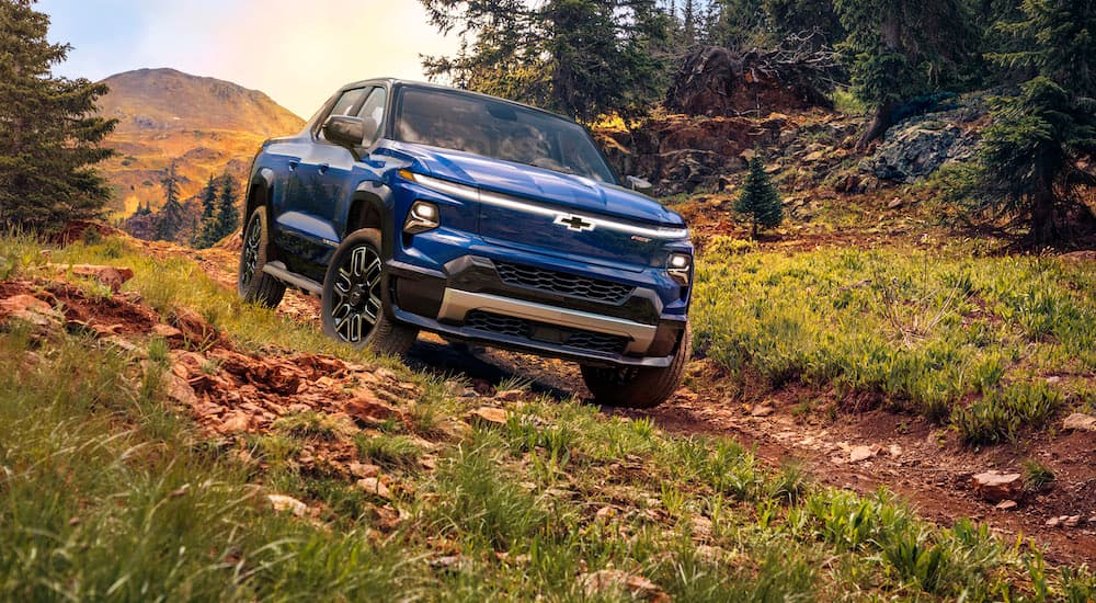 A blue 2024 Chevy Silverado EV RST is shown from the front at an angle while off-road.