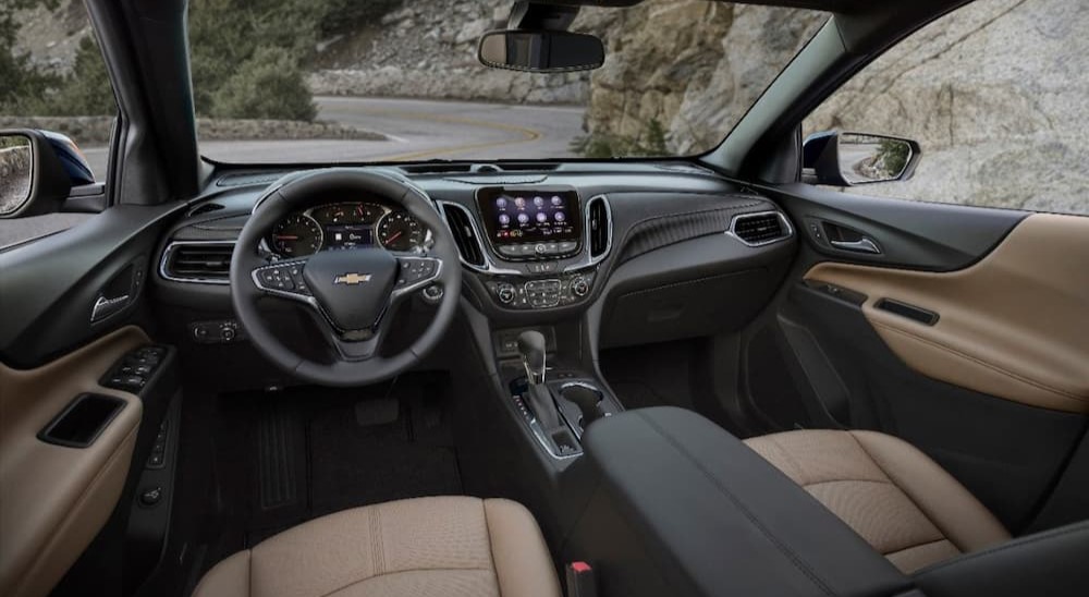 The black and tan interior and dash of a 2024 Chevy Equinox is shown.