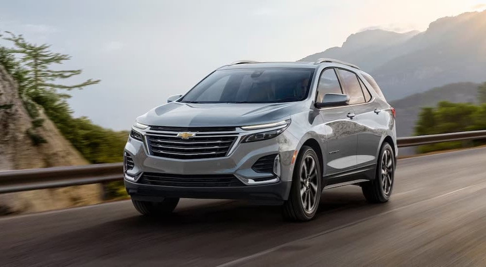 A silver 2024 Chevy Equinox is shown driving on a highway.