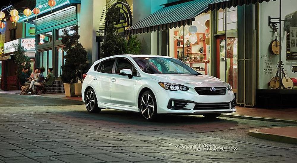 A white 2023 Subaru Impreza is shown from the front at an angle.