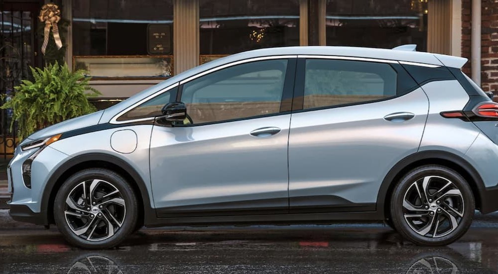 A silver 2023 Chevy Bolt EV is shown parked near a building.