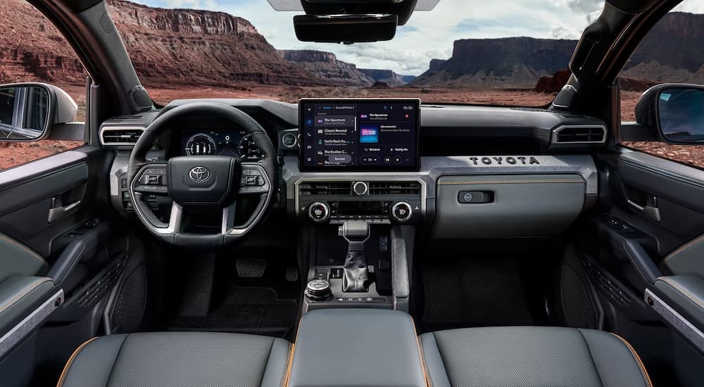 The gray and black interior and dash of a 2024 Toyota Tacoma is shown.