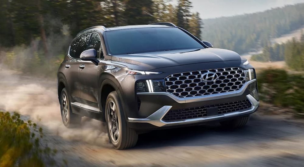 A gray 2022 Hyundai Santa Fe is shown driving on a dirt trail.