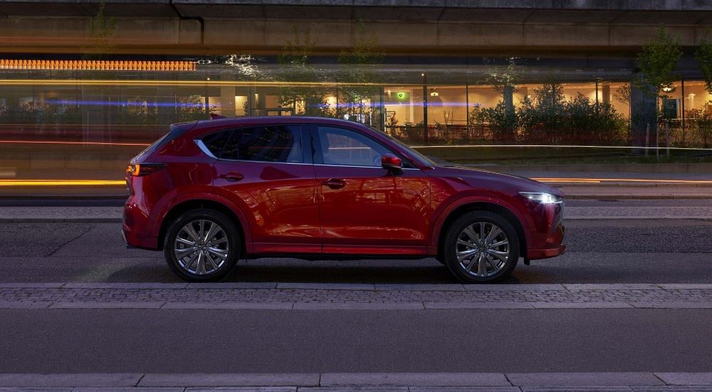 A red 2022 Mazda CX-5 is shown from the side on a city street.