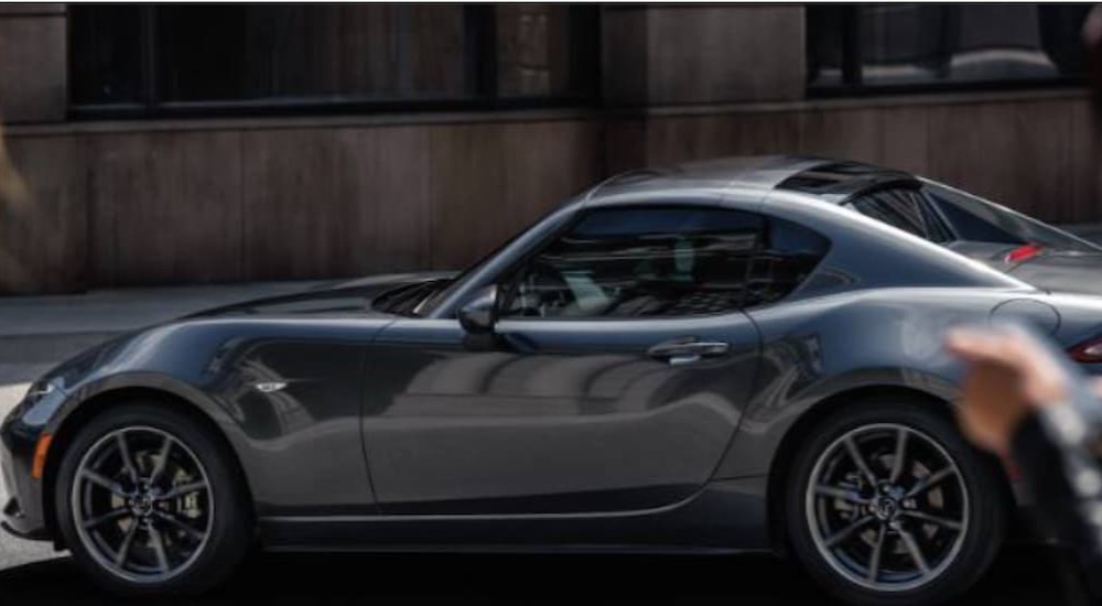 A silver 2023 Mazda MX-5 Miata RF is shown parked on a street.