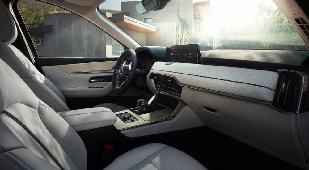 The light gray interior and dash of a 2024 Mazda CX-90 is shown.