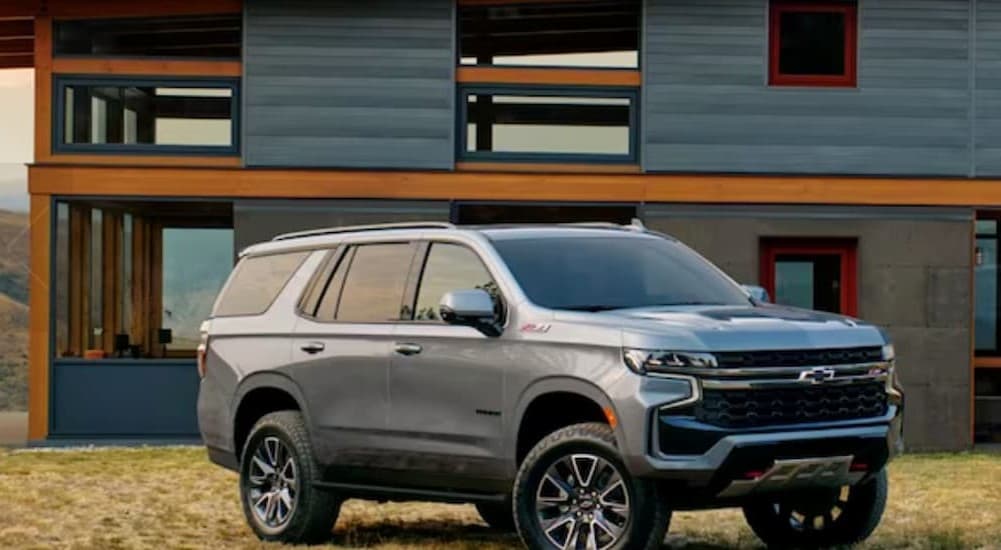 A gray 2023 Chevy Suburban Z71 is shown parked near a house.