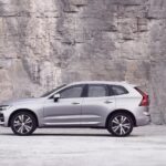 Purchased by Volvo-Dan, a silver 2023 Volvo XC60, is shown parked near a stone wall.