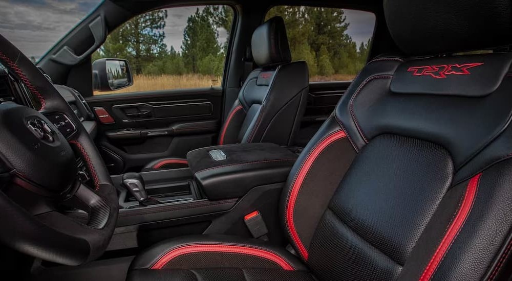 The black and red interior and dash of a 2023 Ram 1500 TRX is shown.