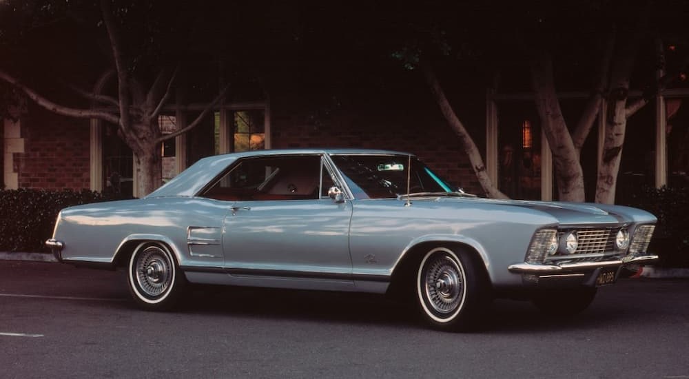 A blue 1963 Buick Riviera is shown at a used Buick dealer.