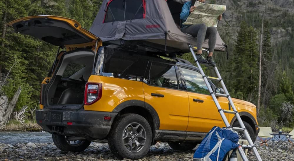 A yellow 2021 Ford Bronco Sport is shown camping off-road.