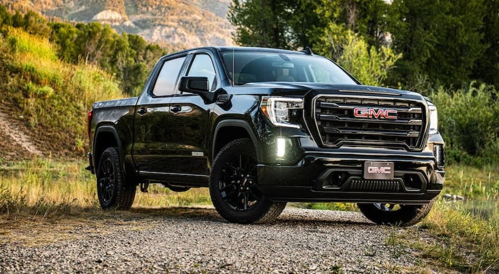 A popular used GMC Sierra for sale, a black 2020 GMC Sierra 1500, is shown parked off-road.