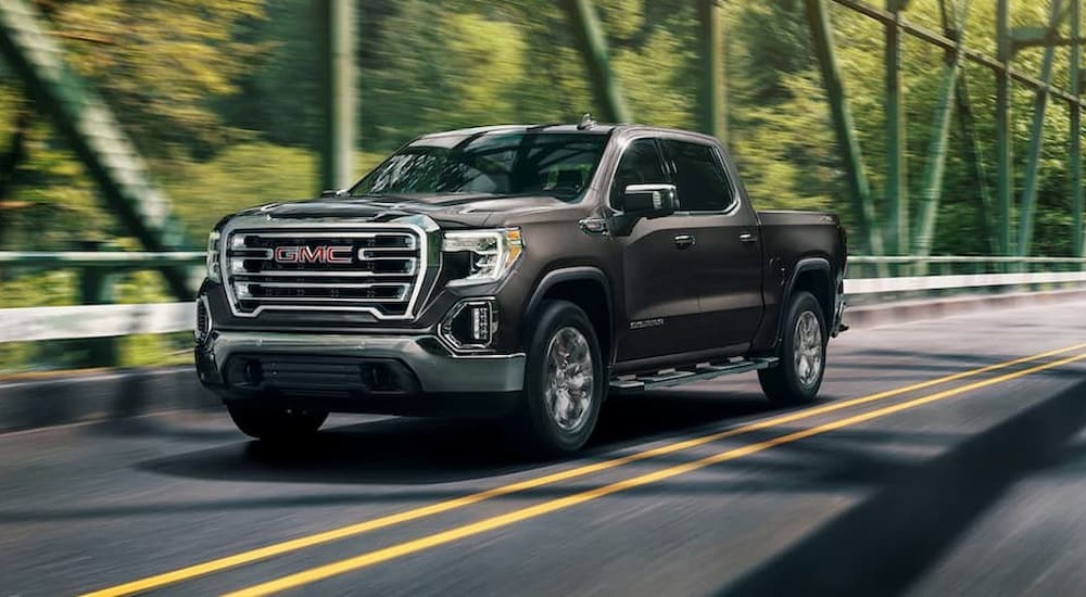 A brown 2020 GMC Sierra 1500 is shown driving on a bridge.