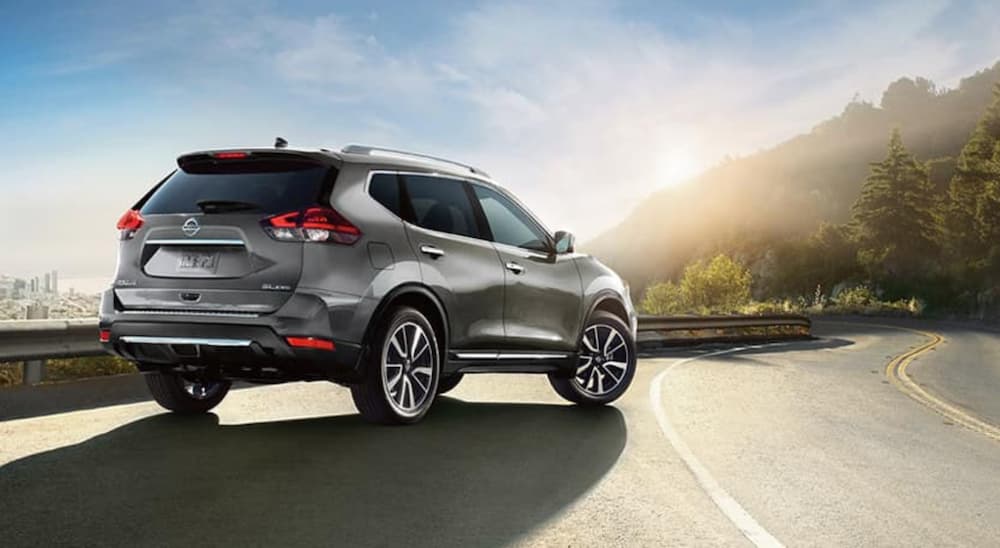 A silver 2018 Nissan Rogue is shown parked on the shoulder of a road.