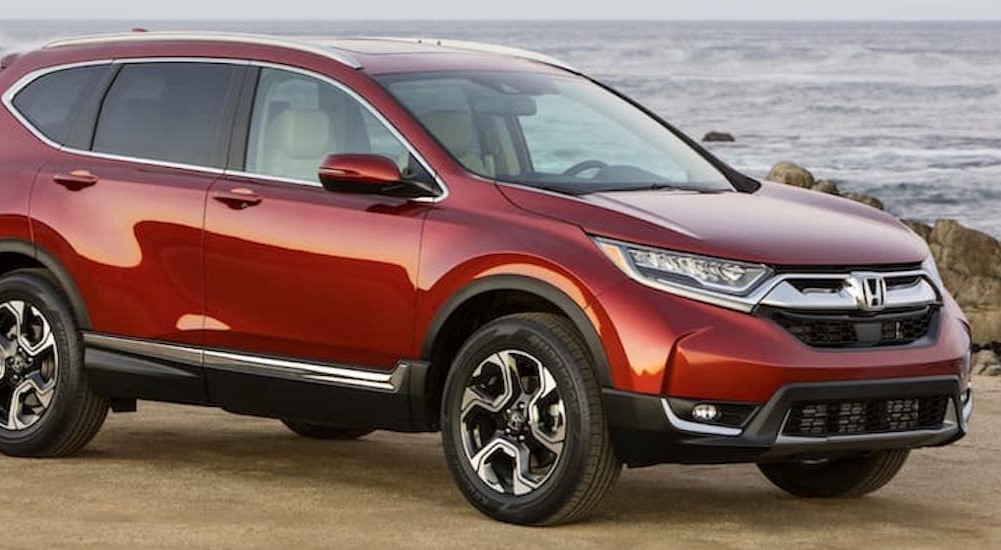 A red 2017 Honda CR-V is shown parked near the ocean.
