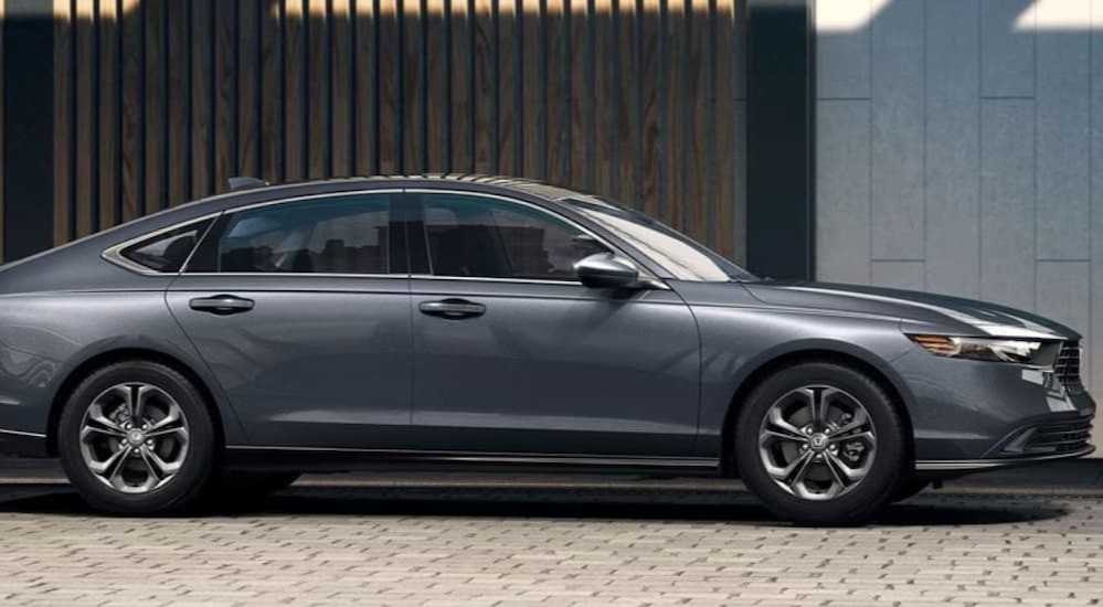 A gray 2023 Honda Accord is shown parked near a building.