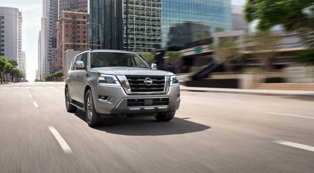A silver 2023 Nissan Armada is shown driving on a city street.