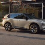 A silver 2023 Nissan Rogue SV Platinum AWD is shown parked near a store.