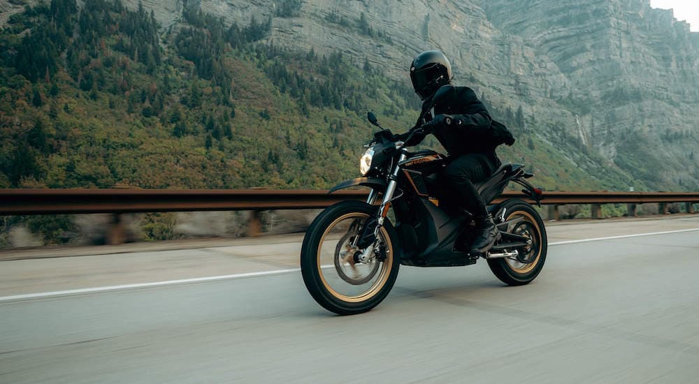 A person is shown driving on a bridge on a black 2023 Zero DSR.