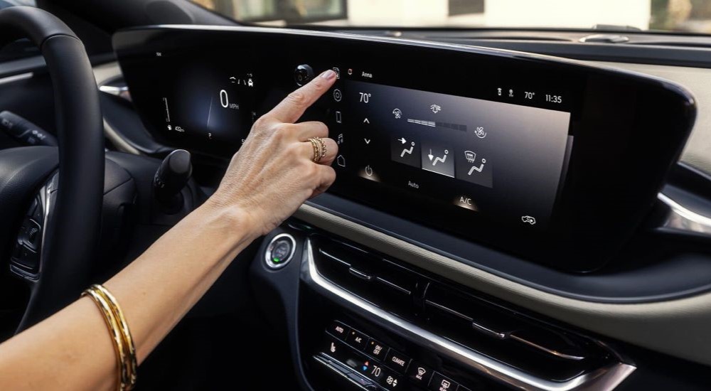 A person is shown using the touchscreen in a 2024 Buick Envista Avenir.