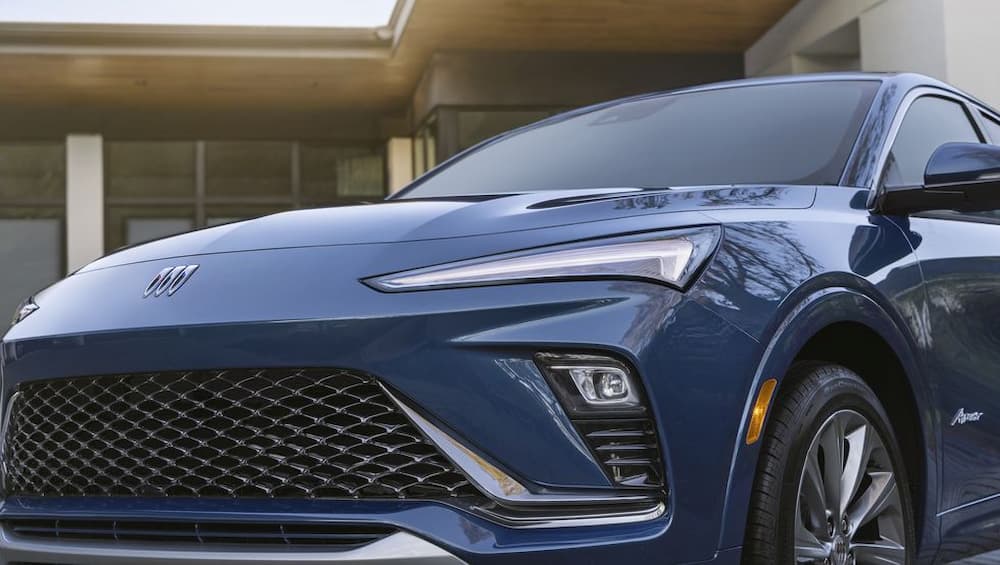 A blue 2024 Buick Envista is shown parked near a house.