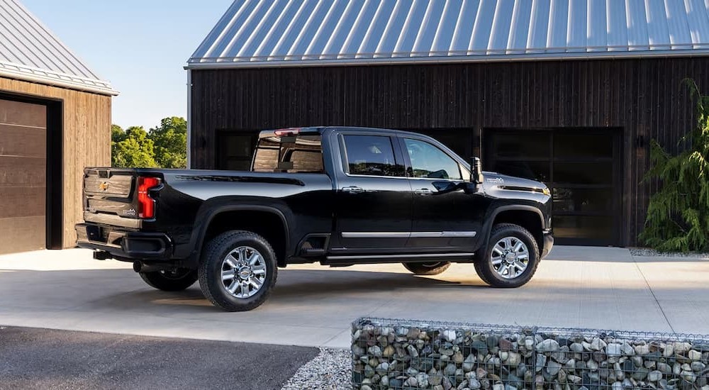 A black 2024 Chevy Silverado 3500HD High Country is shown parked on a driveway.