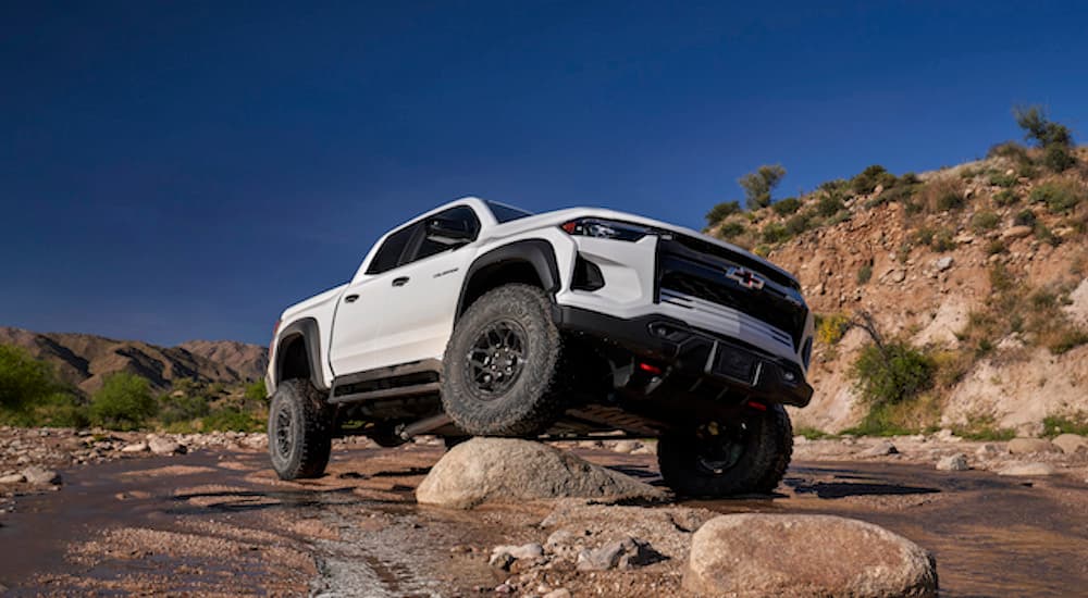 A white 2024 Chevy Colorado ZR2 Bison is shown from the front at a low angle after leaving a dealer that has trucks for sale.