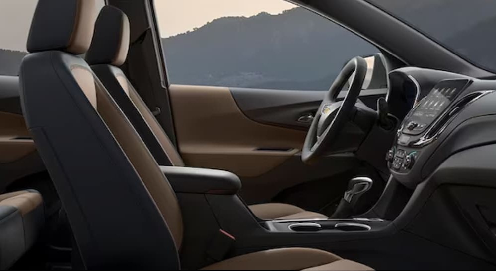 The black and brown interior and dash of a 2024 Chevy Equinox is shown.