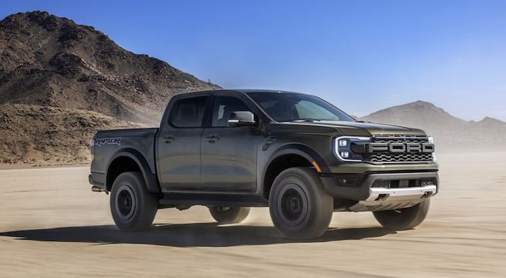 A 2024 Ford Ranger Raptor is shown driving on sand.