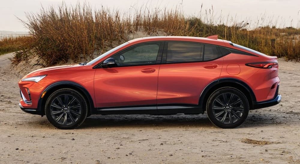 An orange 2024 Buick Envista ST is shown parked near a beach.