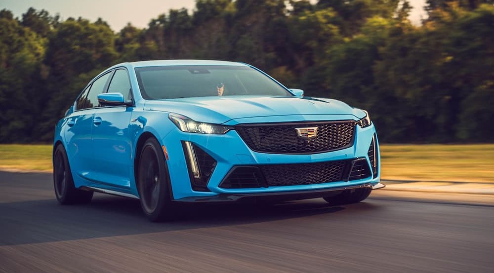 A popular Certified Pre-Owned Cadillac for sale, a blue 2022 Cadillac CT5-V Blackwing, is shown driving on a racetrack.