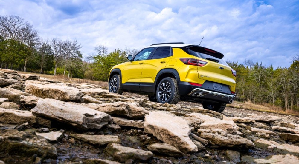 A yellow 2024 Chevy Trailblazer Activ is shown from the rear parked on rocks.