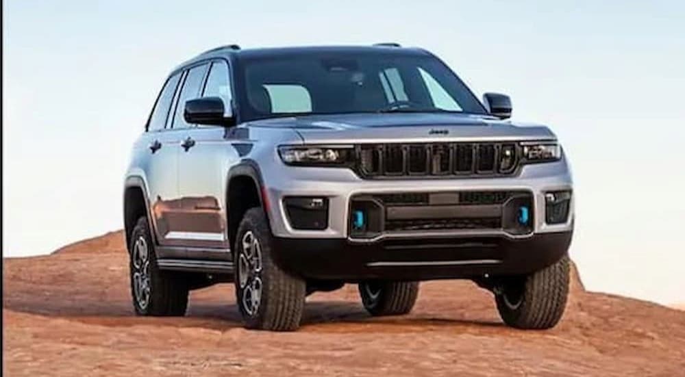 A silver 2023 Jeep Grand Cherokee 4xe is shown parked off-road.