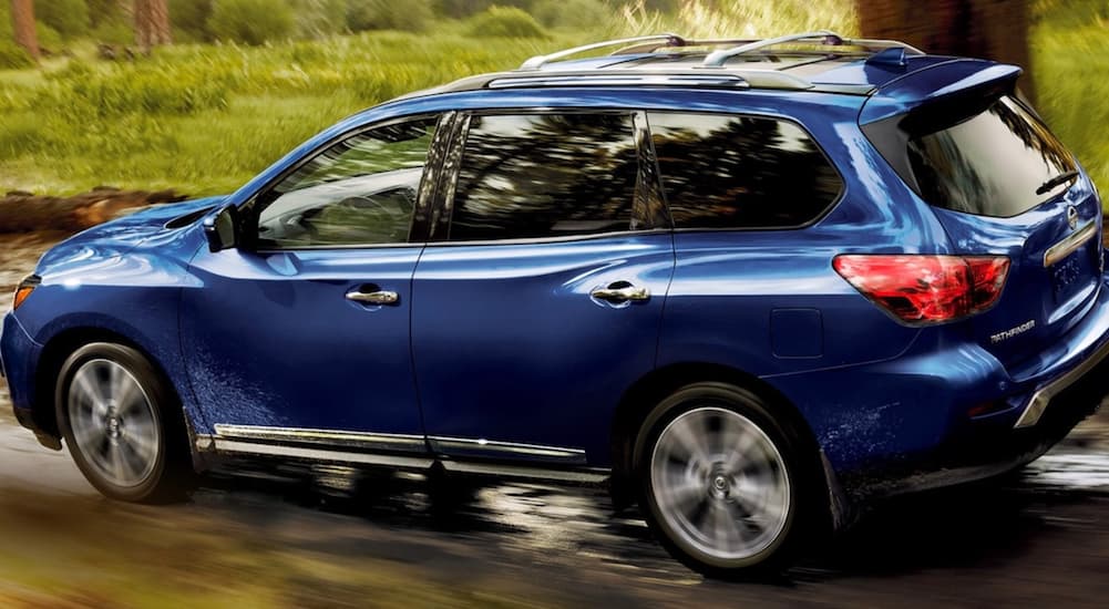 A blue 2020 Nissan Pathfinder is shown driving off-road.