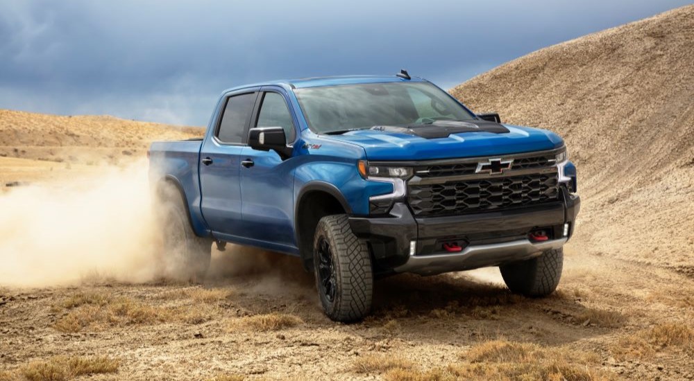A blue 2022 Chevy Silverado ZR2 is shown kicking up dust.