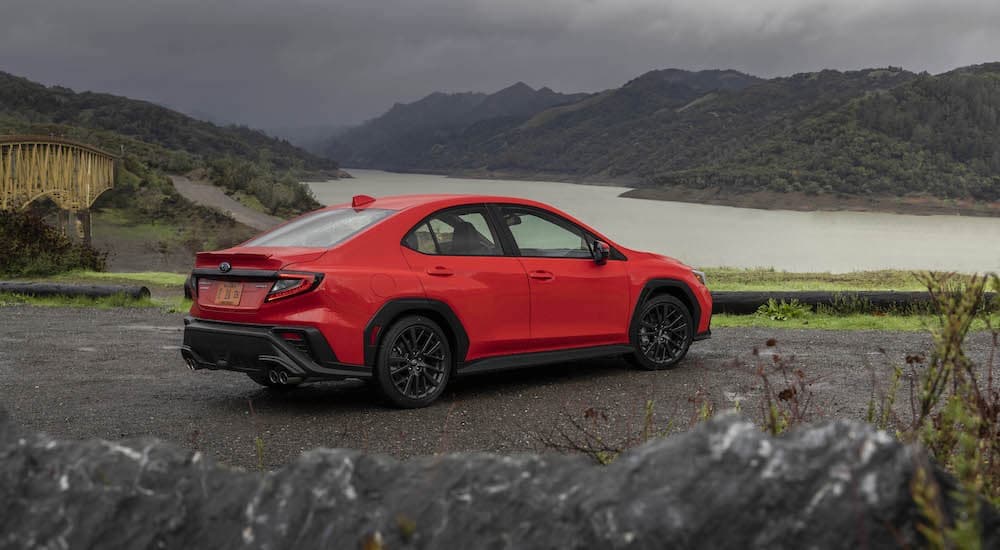 A red 2022 Subaru WRX is shown parked near a lake.
