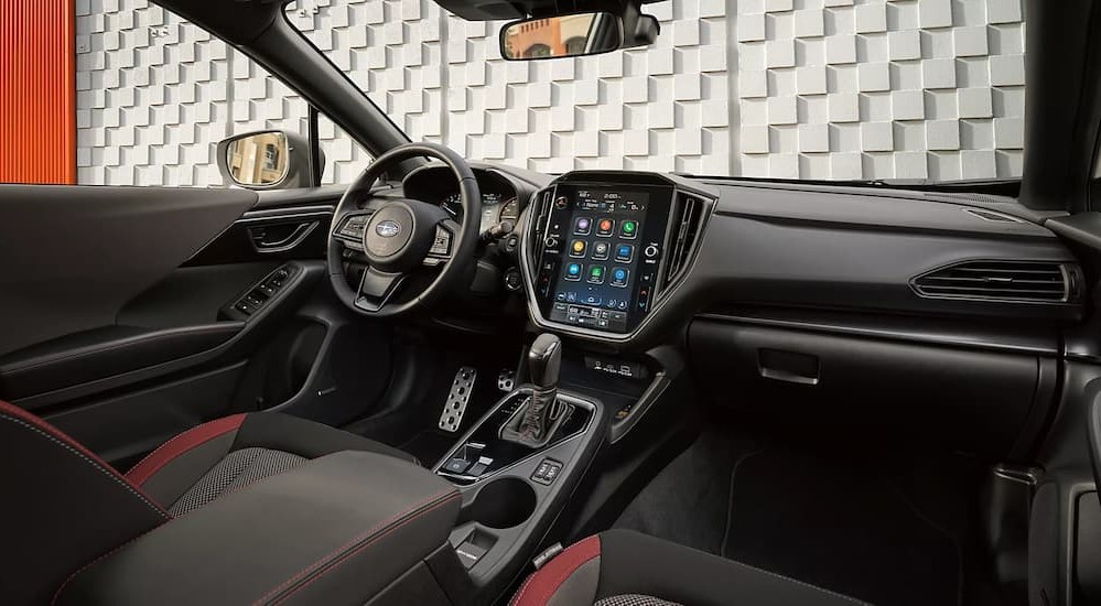 The black and red interior and dash of a 2024 Subaru Impreza is shown.