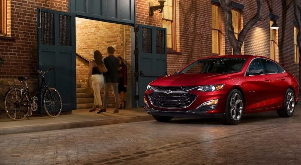 A red 2019 Chevrolet Malibu is shown parked near a building.