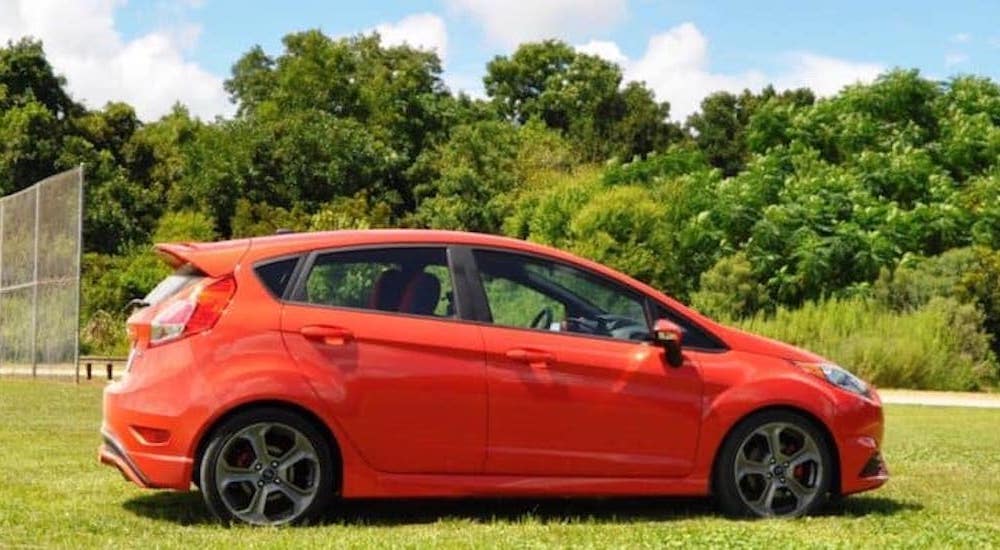 An orange 2015 Ford Fiesta ST is shown from the side.
