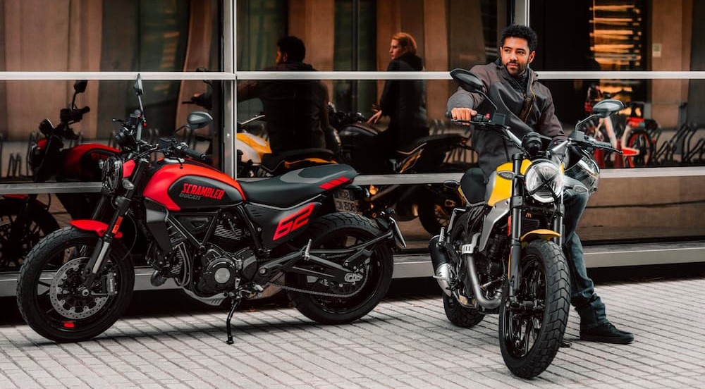 A red and yellow 2023 Ducati Scramblers are shown parked next to one another.