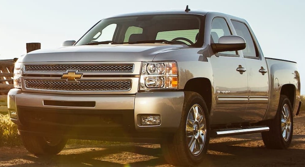 A silver 2013 Chevy Silverado 1500 is shown parked after visiting a Chevy Silverado for sale.