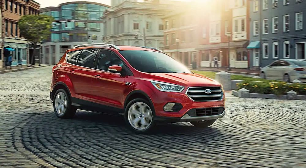 A red 2019 Ford Escape is shown driving on a city road.